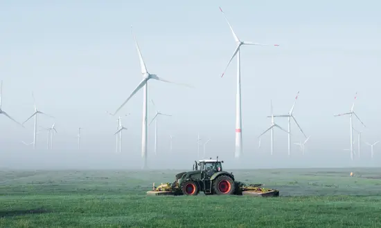 Acker für Windrad verpachten Ein Traktor fährt auf einem Acker für Windrad verpachten