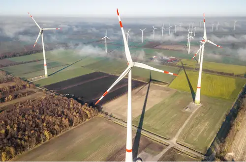 Weitläufige Landschaft in Sachsen mit Feldern, Wald und zahlreichen Windrädern bis zum Horizont.