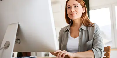 Erstgespräch und Beratung Frau arbeitet am Computer im Büro.