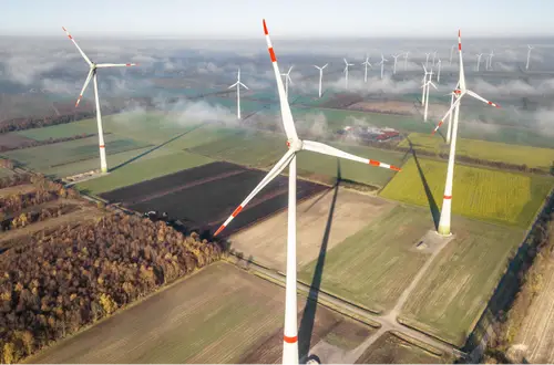 Weitläufige Landschaft in Sachsen mit Feldern, Wald und zahlreichen Windrädern bis zum Horizont.